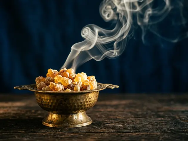 Incense smoke curling over loose resin and a brass censer